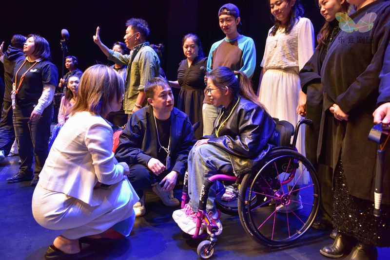 轮椅上的孙妖妖与乌镇戏剧节发起人、总监制黄磊交流（前排中间）     乐意剧团供图
